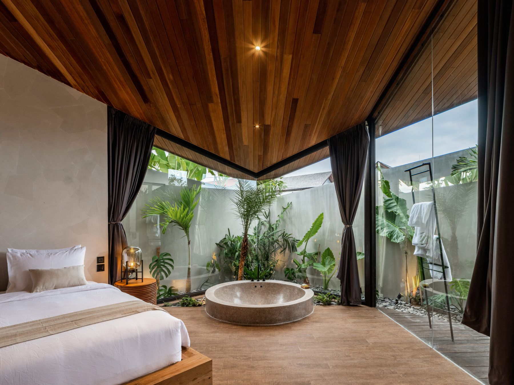 Bedroom opening onto a private garden with a stone bathtub