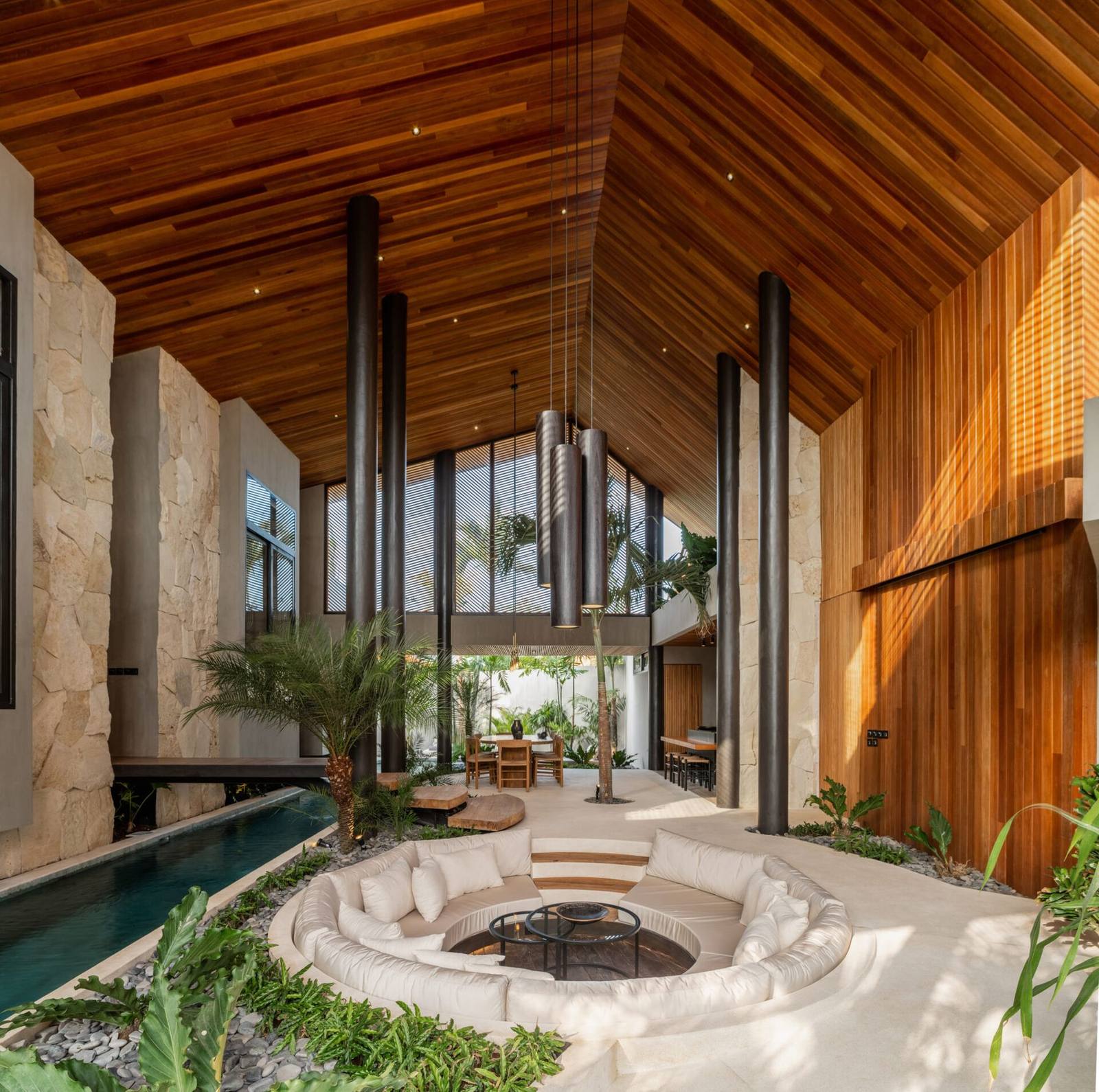Vaulted open-air living space with a sunken lounge and pool alongside