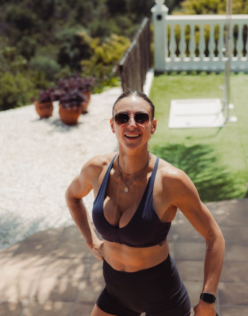 Beth smiling poolside in training kit on a sunny day