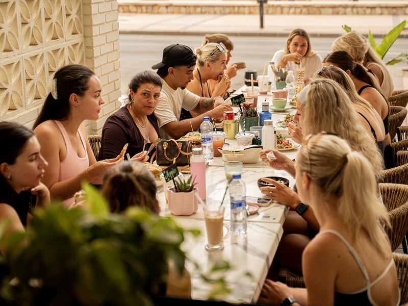 Guests talking over a long lunch table on the terrace