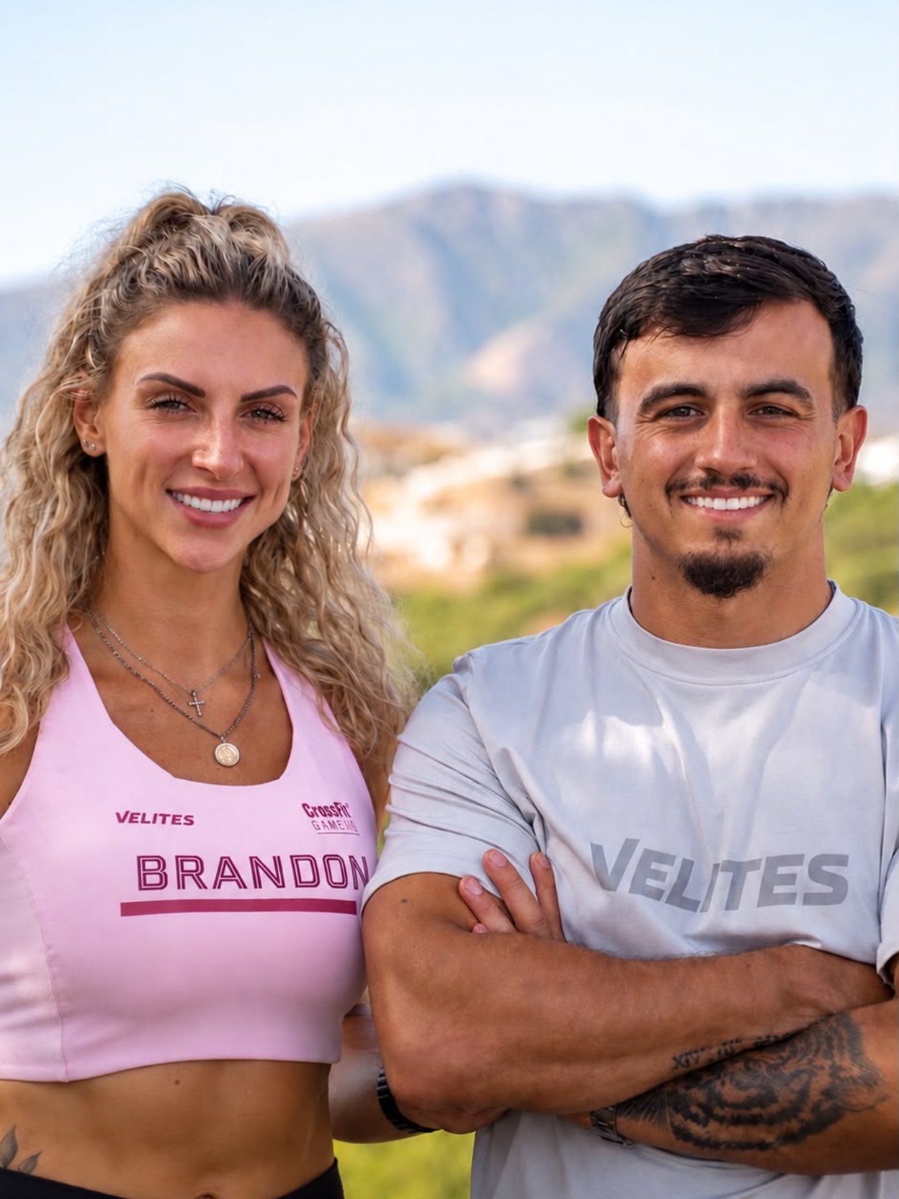 Beth and Danny, the founders of Evolve Escapes, standing together outside with hills behind them