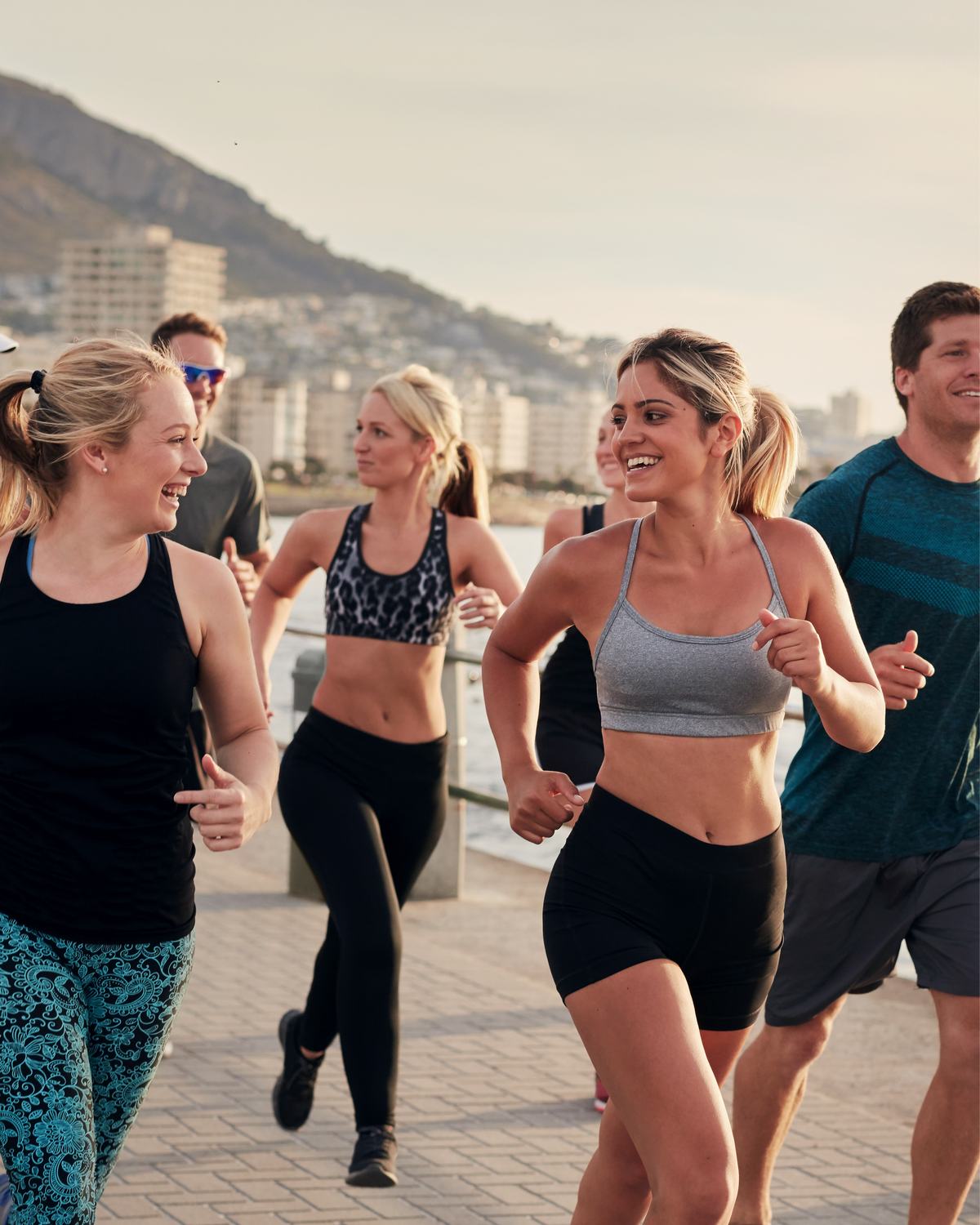 Group of runners on a coastal promenade in morning light