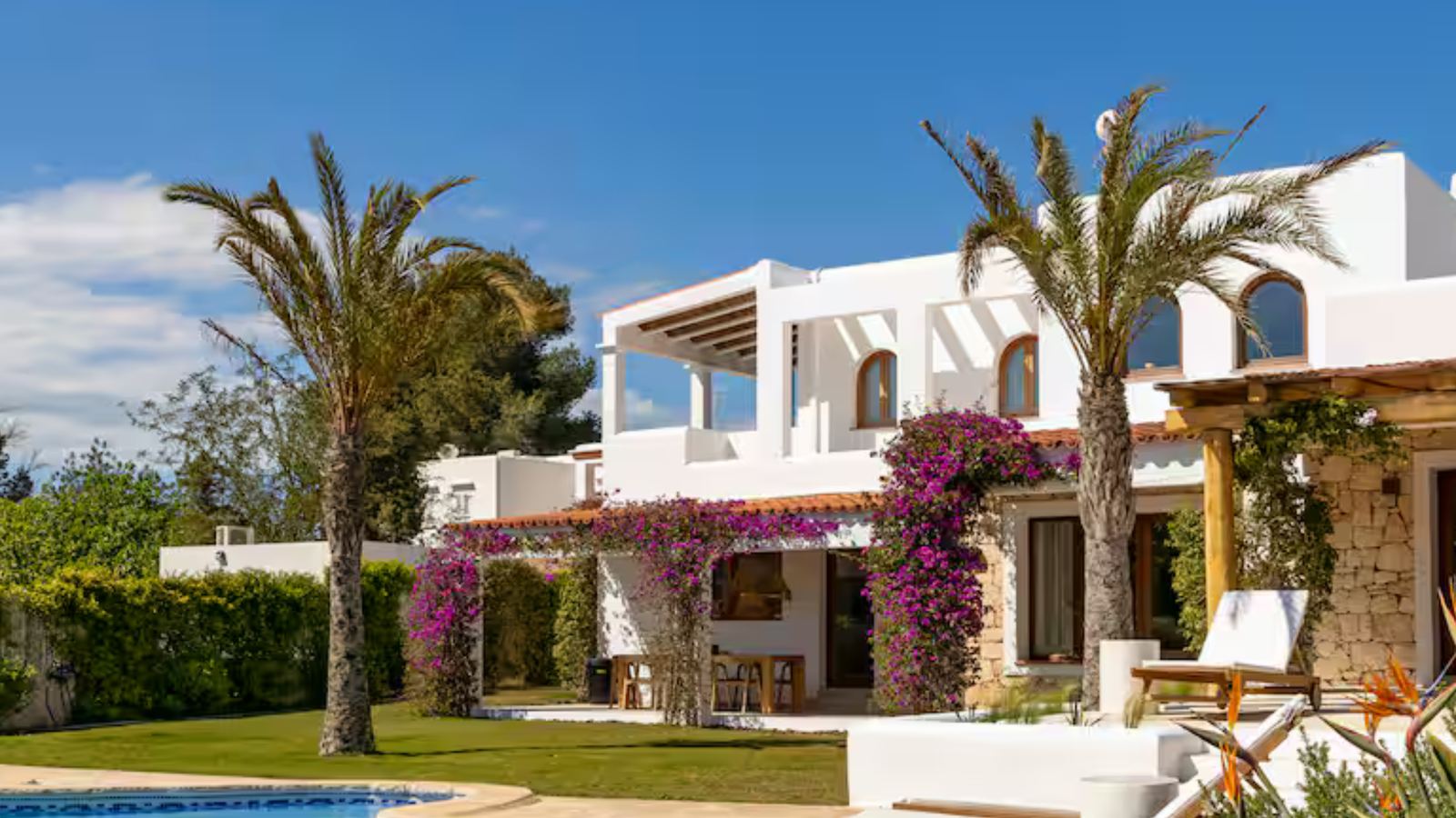 White finca with bougainvillea, palm trees and a private pool in Ibiza