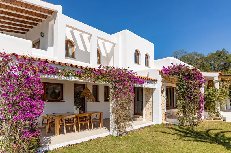 The covered outdoor dining table under pink bougainvillea