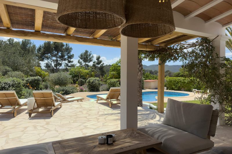 A shaded terrace lounge looking out to the pool and the hills