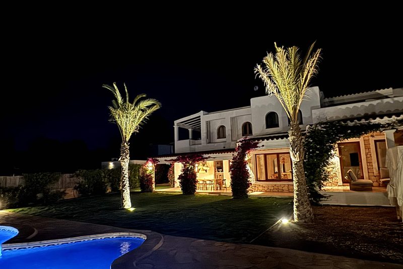 The villa and pool lit up at night