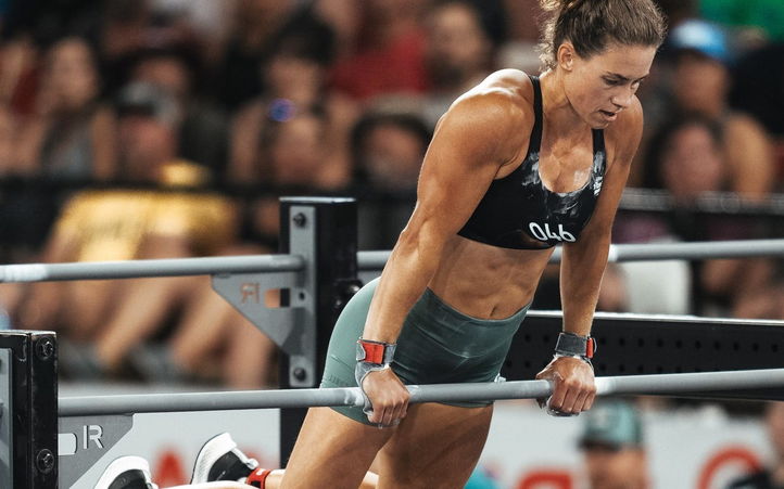 Emily Rolfe mid bar muscle-up in front of a CrossFit Games crowd