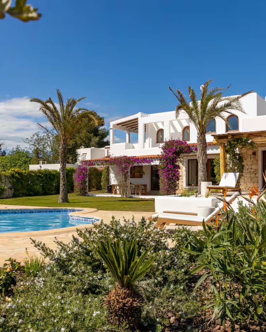 White finca with bougainvillea, palm trees and a private pool