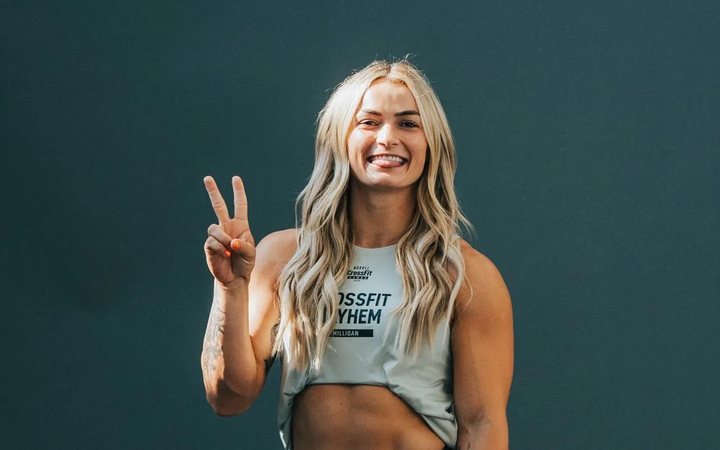 Kyra Milligan smiling and making a peace sign