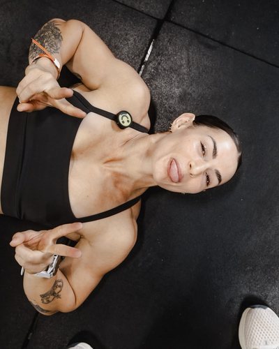 Kyra Milligan lying on a gym floor, pulling a playful face at the camera